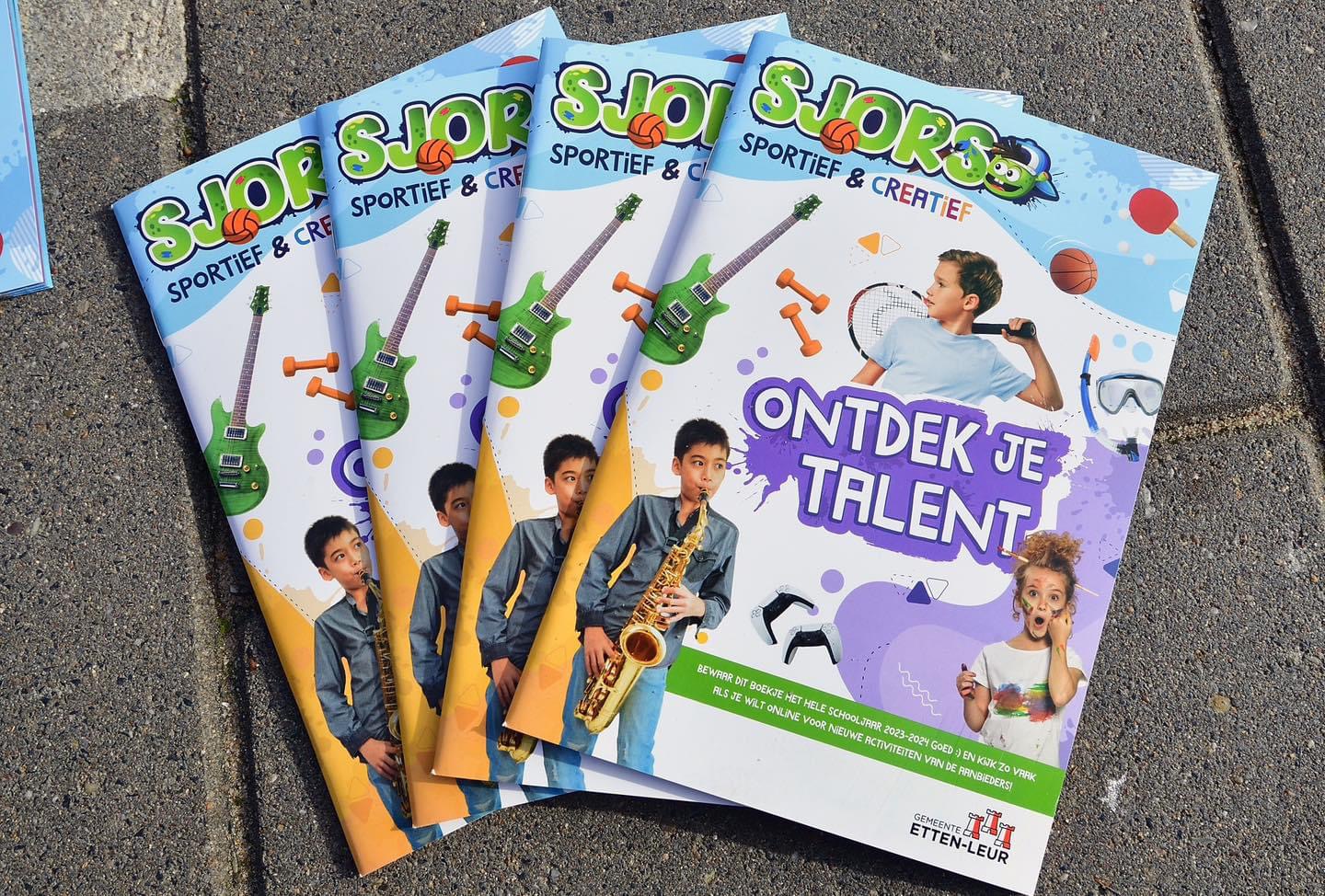 Vier programmaboekjes van Sjors sportief en creatief met de titel Ontdek je talent liggen bij elkaar op de stoep