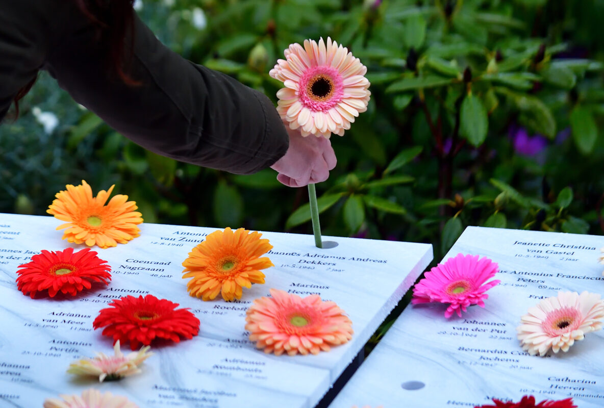 Bloemen worden gestoken in een tableau tijdens Dodenherdenking